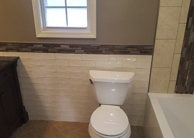 A bathroom with a toilet and tub in it