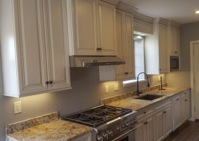 A kitchen with white cabinets and granite countertops.