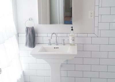 A white bathroom with a sink and mirror