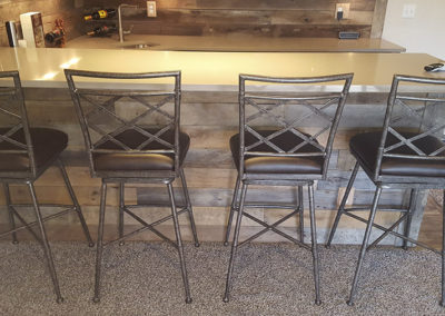 A bar with four chairs and a counter.